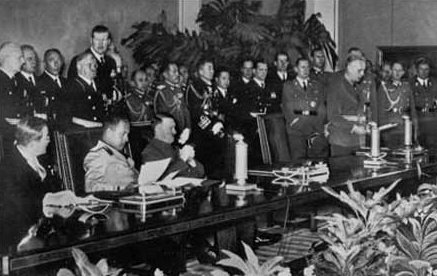 The signing of the Tripartite Pact by Germany, Japan, and Italy on 27 September 1940 in Berlin. Seated from left to right are the Japanese ambassador to Germany Saburō Kurusu, Italian Minister of Foreign Affairs Galeazzo Ciano, and Adolf Hitler.